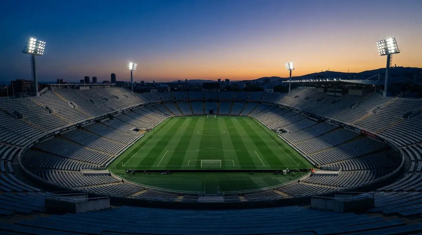 Een leeg voetbalstadion met lichtmasten bij schemering